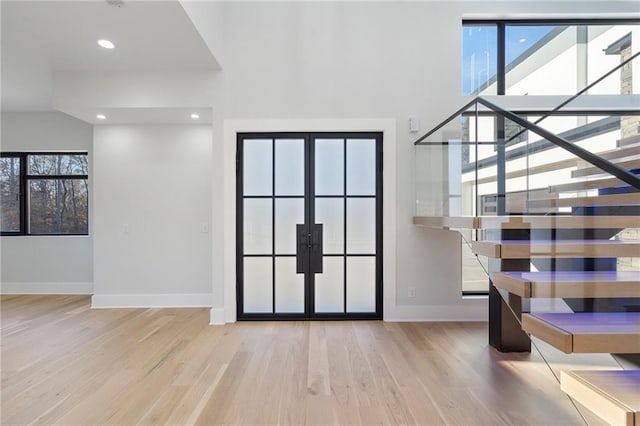 entrance foyer featuring a wealth of natural light, french doors, and light wood-type flooring