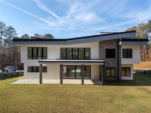 rear view of property with a yard and a patio area