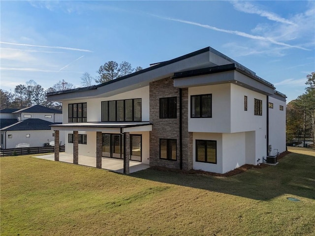 rear view of house with a lawn, central air condition unit, and a patio area