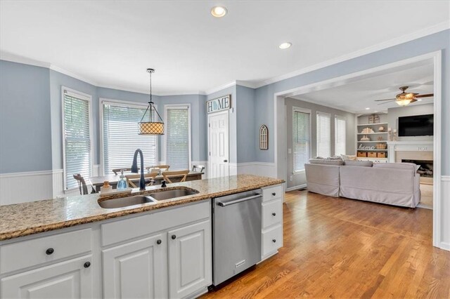 3921 Upland Way, Marietta, GA 30066 - kitchen featuring stainless steel dishwasher, a sink, wainscoting, a fireplace, and white cabinets