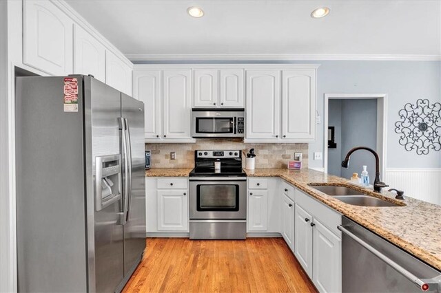 3921 Upland Way, Marietta, GA 30066 - kitchen featuring white cabinets, light stone counters, a sink, crown molding, and appliances with stainless steel finishes