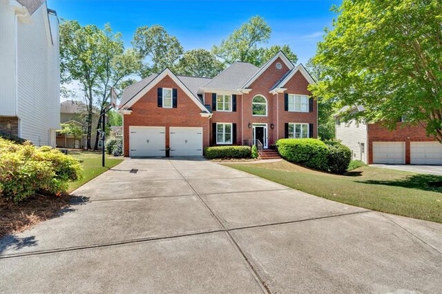 3921 Upland Way, Marietta, GA 30066 - colonial inspired home with brick siding, an attached garage, a front lawn, and concrete driveway