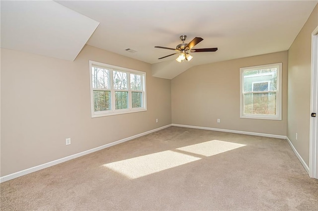 carpeted spare room featuring ceiling fan and lofted ceiling