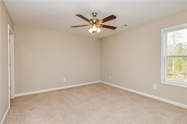 carpeted spare room featuring ceiling fan