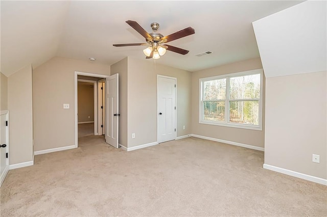 unfurnished bedroom featuring ceiling fan, light carpet, and vaulted ceiling