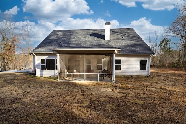 rear view of property with a sunroom and a yard