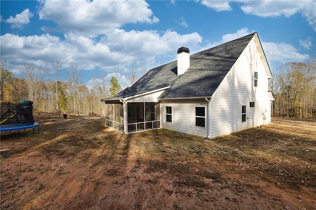 rear view of house with a trampoline and a sunroom