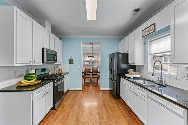 859 Scales Rd, Suwanee, GA 30024 - kitchen featuring stainless steel appliances, a sink, dark countertops, backsplash, and crown molding