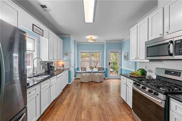 859 Scales Rd, Suwanee, GA 30024 - kitchen with stainless steel appliances, a sink, ornamental molding, backsplash, and wood finished floors