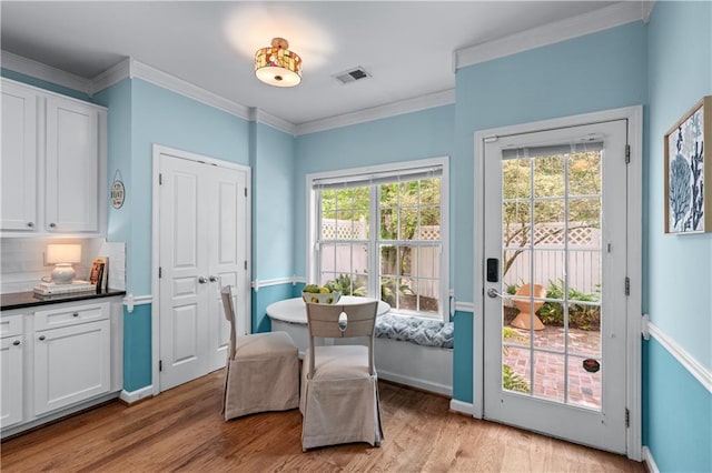 859 Scales Rd, Suwanee, GA 30024 - dining area with healthy amount of natural light, light wood finished floors, ornamental molding, and baseboards