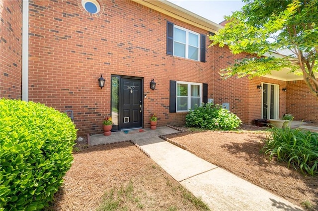 property entrance featuring brick siding
