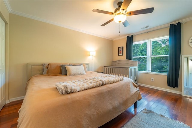 bedroom featuring dark wood finished floors, ornamental molding, baseboards, and ceiling fan