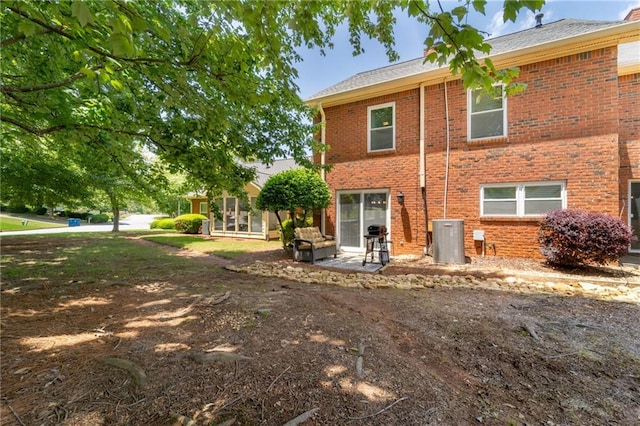 back of house featuring brick siding, a patio area, and central air condition unit