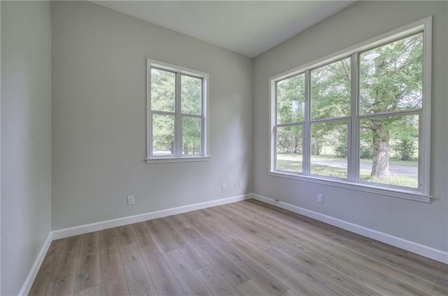spare room with wood finished floors and baseboards