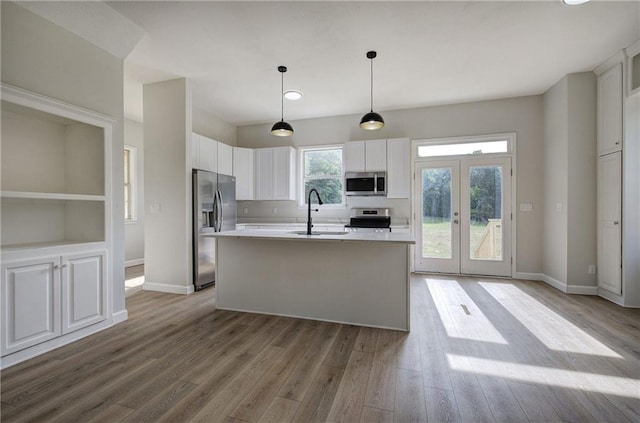 kitchen featuring appliances with stainless steel finishes, a sink, light countertops, and white cabinets