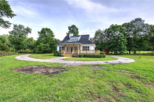 bungalow-style home with a porch, a front yard, and a chimney