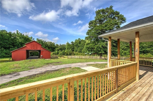 wooden terrace featuring a barn and an outdoor structure