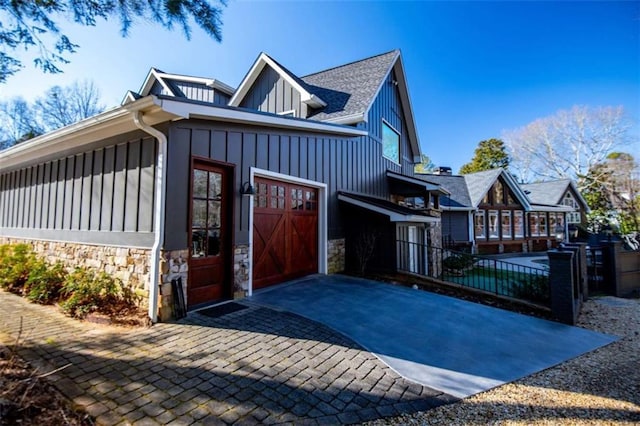 202 Hickory Chase, Carrollton, GA 30117 - view of property exterior with board and batten siding, driveway, stone siding, and fence