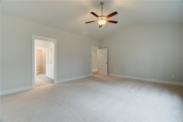 unfurnished bedroom with light carpet, ensuite bath, vaulted ceiling, and ceiling fan