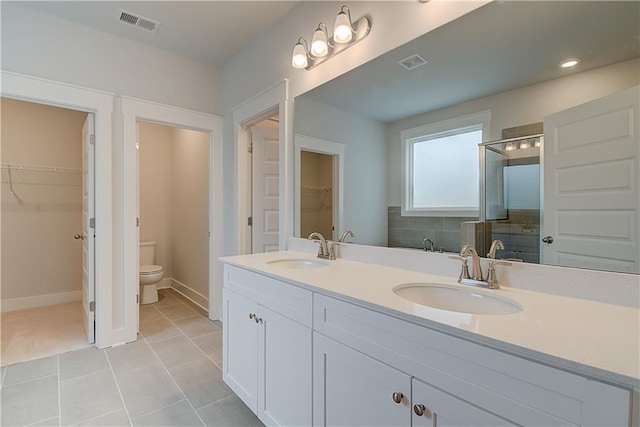 bathroom with tile patterned flooring, toilet, an enclosed shower, and vanity