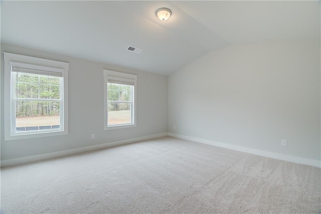 carpeted empty room with vaulted ceiling