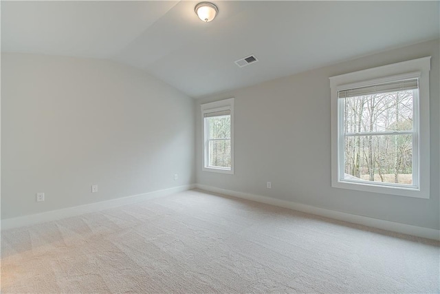 carpeted empty room with lofted ceiling