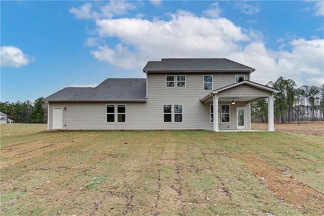 rear view of house with a lawn and ceiling fan