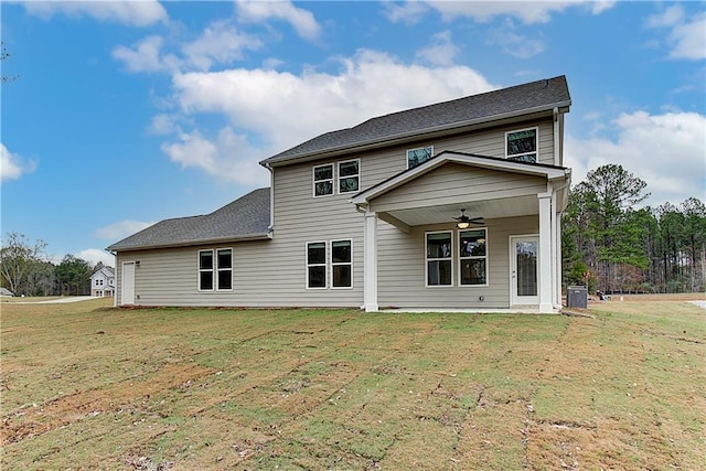 rear view of house with ceiling fan and a yard