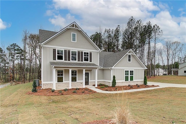 view of front of property featuring central AC unit, covered porch, and a front lawn