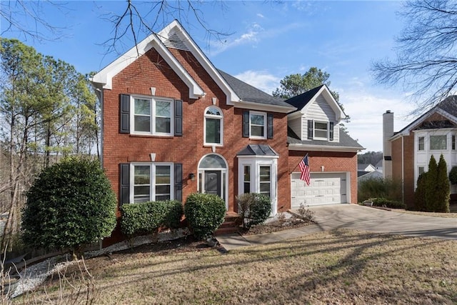 colonial house featuring brick siding, driveway, and an attached garage