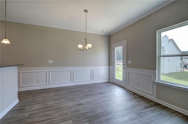 unfurnished dining area featuring ornamental molding, a chandelier, and dark hardwood / wood-style flooring