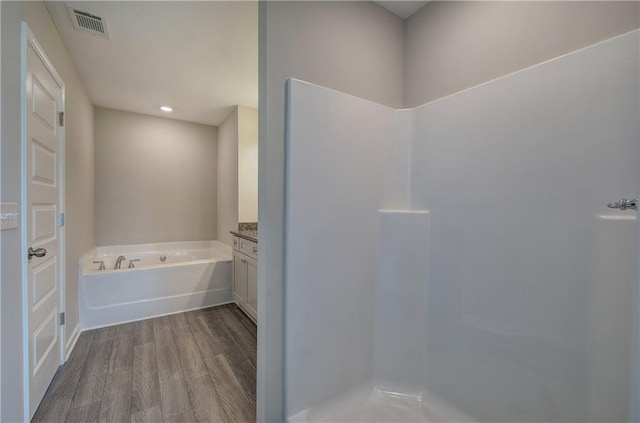 bathroom with wood-type flooring, a bathtub, and vanity