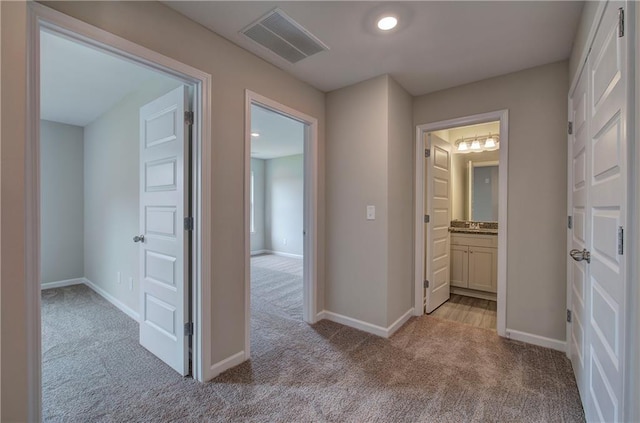 hall featuring light colored carpet