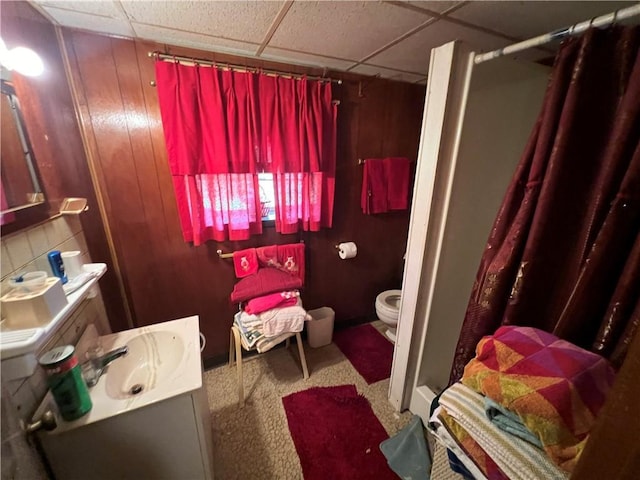 full bath with a drop ceiling, curtained shower, toilet, and vanity