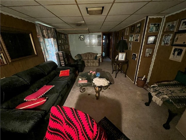 living area featuring a drop ceiling and carpet floors