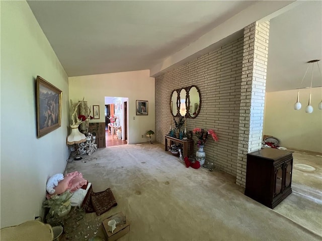 interior space featuring lofted ceiling, brick wall, and carpet floors