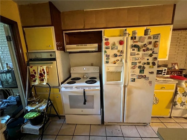 kitchen with under cabinet range hood, white appliances, and light tile patterned flooring