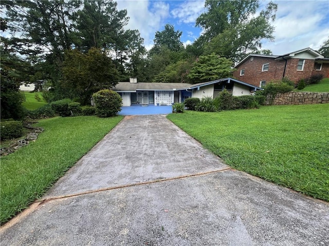 ranch-style house with a front yard and concrete driveway