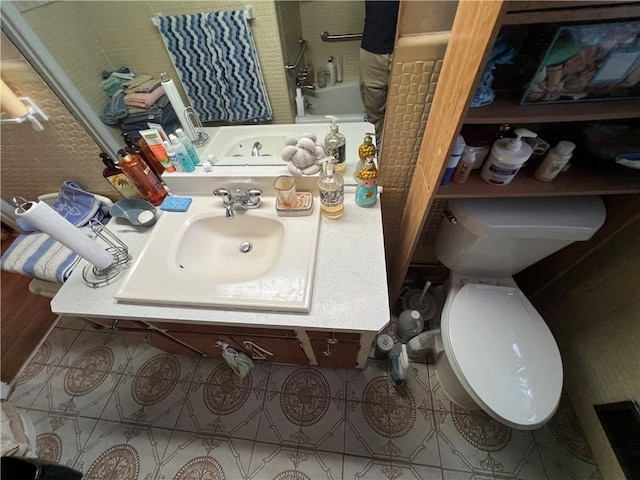 bathroom featuring a sink, visible vents, toilet, and tile patterned flooring