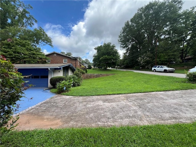 view of yard with a garage and driveway