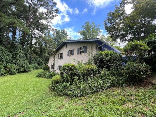 view of side of home with a yard and brick siding