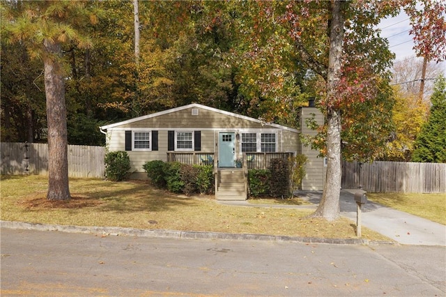 view of front of home featuring a porch, a front lawn, and fence