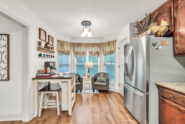 1464 Fieldstone Ct, Winder, GA 30680 - kitchen with stainless steel refrigerator with ice dispenser, light wood-type flooring, and a textured ceiling
