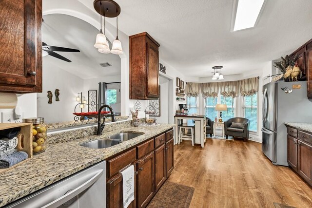 1464 Fieldstone Ct, Winder, GA 30680 - kitchen featuring stainless steel appliances, pendant lighting, light wood finished floors, and healthy amount of natural light