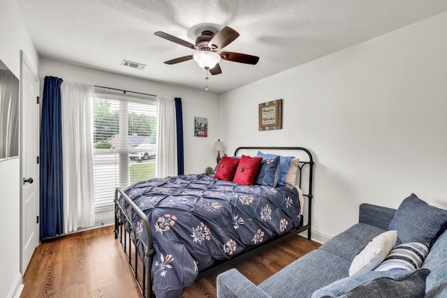 1464 Fieldstone Ct, Winder, GA 30680 - bedroom with wood finished floors, a textured ceiling, and ceiling fan