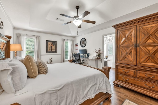 1464 Fieldstone Ct, Winder, GA 30680 - bedroom featuring a tray ceiling, wood finished floors, an office area, ceiling fan, and ornamental molding