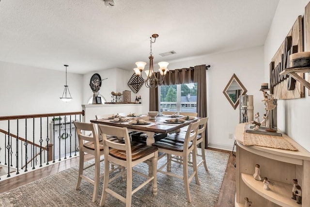 1464 Fieldstone Ct, Winder, GA 30680 - dining space featuring a chandelier, light wood-type flooring, and a textured ceiling