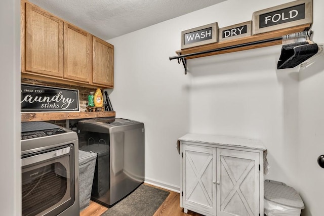 1464 Fieldstone Ct, Winder, GA 30680 - washroom featuring cabinet space, washer and dryer, and light wood-style floors