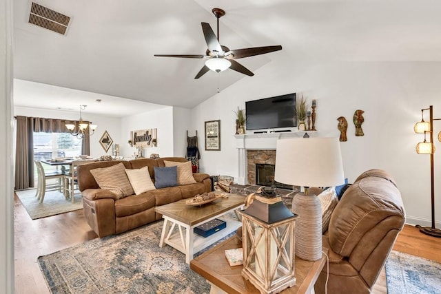 1464 Fieldstone Ct, Winder, GA 30680 - living area featuring ceiling fan, a fireplace, a chandelier, lofted ceiling, and wood finished floors
