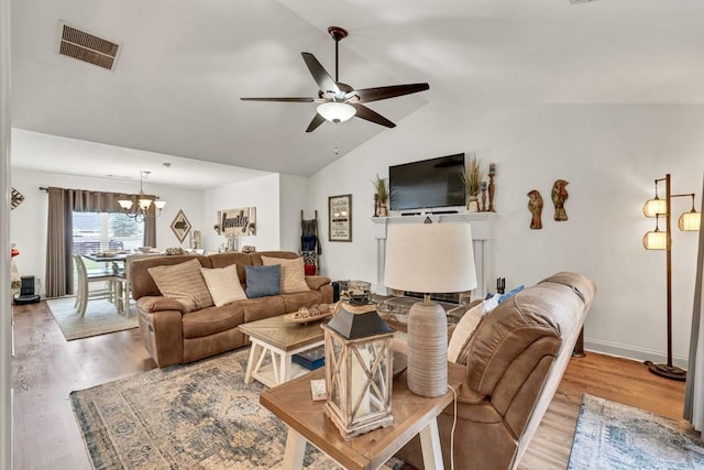 1464 Fieldstone Ct, Winder, GA 30680 - living room with a ceiling fan, light wood-style flooring, a chandelier, and vaulted ceiling